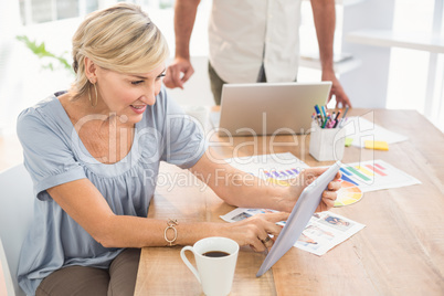 Smiling businesswoman scrolling on a tablet