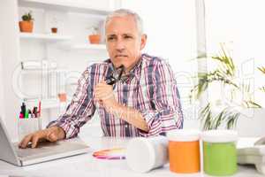 Thoughtful casual businessman sitting at working desk