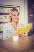 Smiling blonde holding yellow book