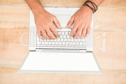 Hands working on blank screen laptop