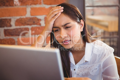 Businesswoman having coffee and working on laptop