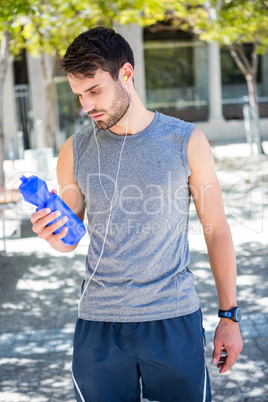 Handsome runner holding a water bottle