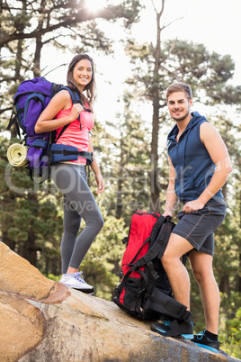 Young happy joggers standing on rock looking at camera