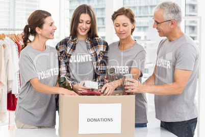 Smiling volunteers sorting donation box