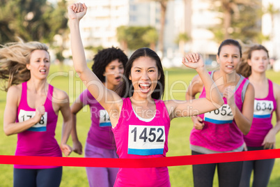 Cheering woman winning breast cancer marathon