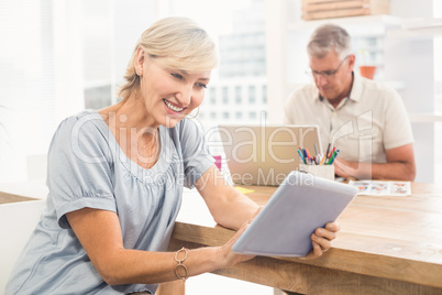 Smiling businesswoman scrolling on a tablet