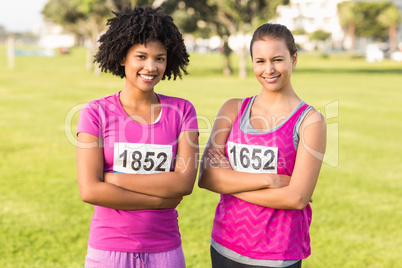 Two smiling runners supporting breast cancer marathon