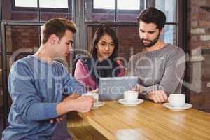 Group of friends enjoying a coffee with a tablet