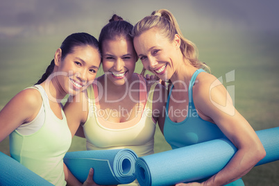 Laughing sporty women with exercise mats