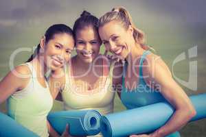 Laughing sporty women with exercise mats