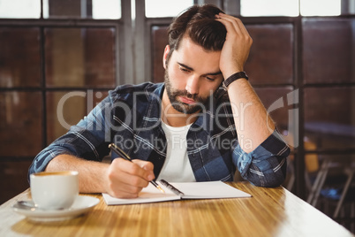 Young man taking notes in his notebook