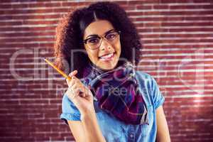 Smiling attractive hipster holding pen
