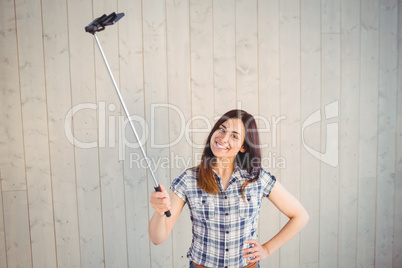 Pretty hipster taking a selfie with stick