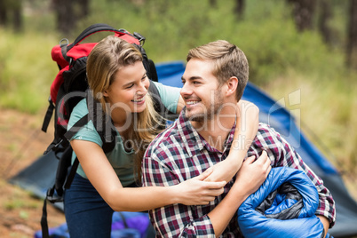 Young pretty hiker couple holding a sleeping bag and backpack