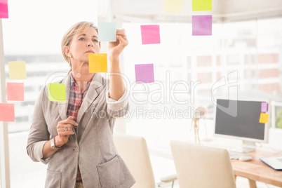 Casual businesswoman writing on sticky notes