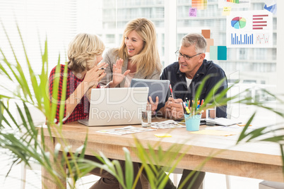 Smiling business team discussing over a tablet