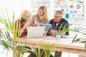 Smiling business team discussing over a tablet