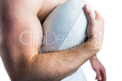 Shirtless rugby player holding ball