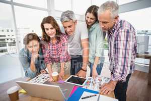 Casual business team having a meeting using laptop