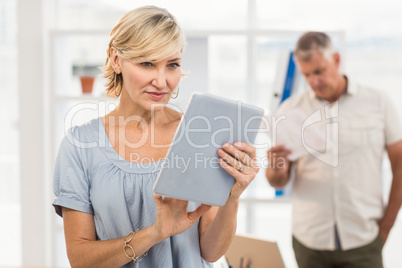 Smiling businesswoman scrolling on a tablet