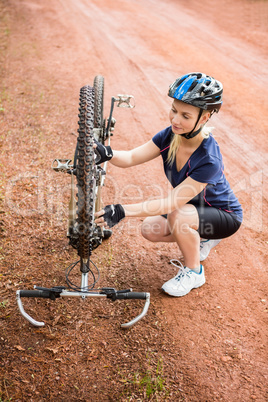 Athletic blonde checking her mountain bike