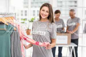 Smiling female volunteer choosing clothes