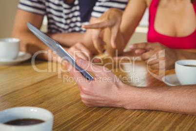 Happy friends laughing while looking at tablet Happy friends laughing while looking at tablet