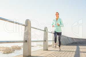 Focused fit blonde jogging at promenade