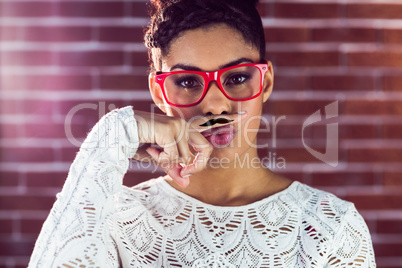 Portrait of a happy hipster wearing a fake mustache