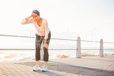 Sweating sporty woman resting at promenade