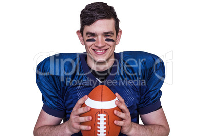 Smiling american football player holding a ball