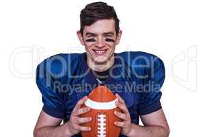 Smiling american football player holding a ball