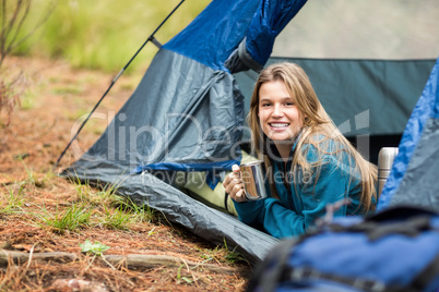 Portrait of a young pretty hiker lying in a tent