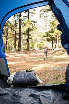 Blonde camper walking away from tent