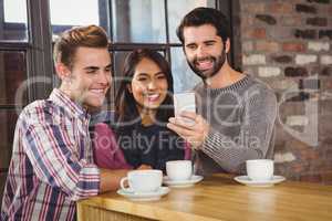 Group of friends taking selfies with a smartphone