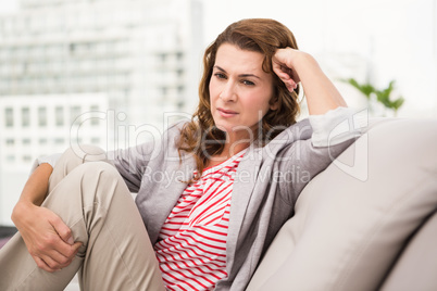Worried casual businesswoman sitting on couch