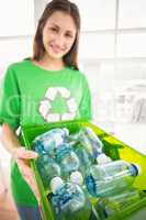 Smiling eco-minded brunette showing recycling box