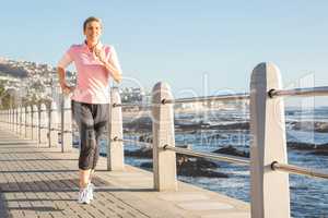 Sporty woman jogging at promenade