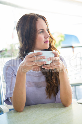 Pretty brunette enjoying a cappuccino