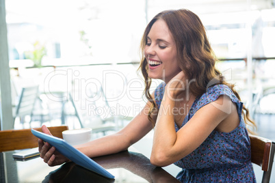 Woman having coffee and using her tablet