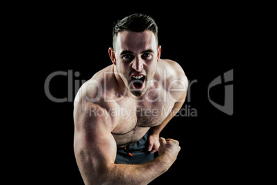 Handsome bodybuilder flexing and shouting