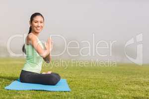 Smiling sporty woman doing the lotus pose