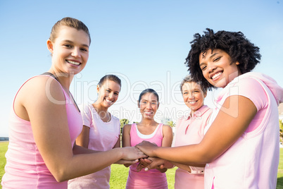 Women wearing pink for breast cancer and putting hands together