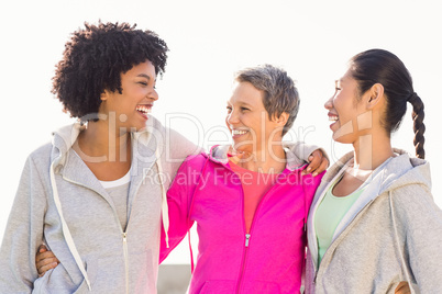 Laughing sporty women with arms around each other