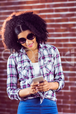 Attractive hipster with sunglasses texting