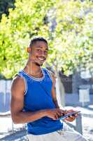 Smiling athletic man using tablet computer