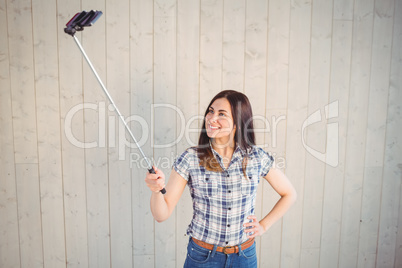 Pretty hipster taking a selfie with stick