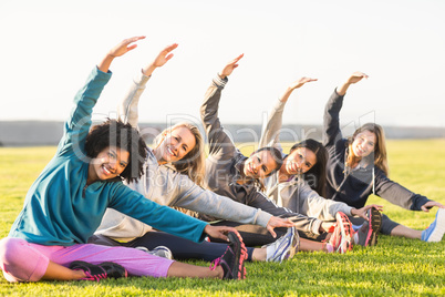 Smiling sporty women stretching during fitness class