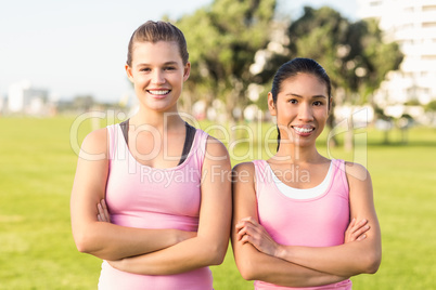 Two smiling women wearing pink for breast cancer