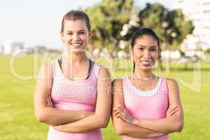 Two smiling women wearing pink for breast cancer